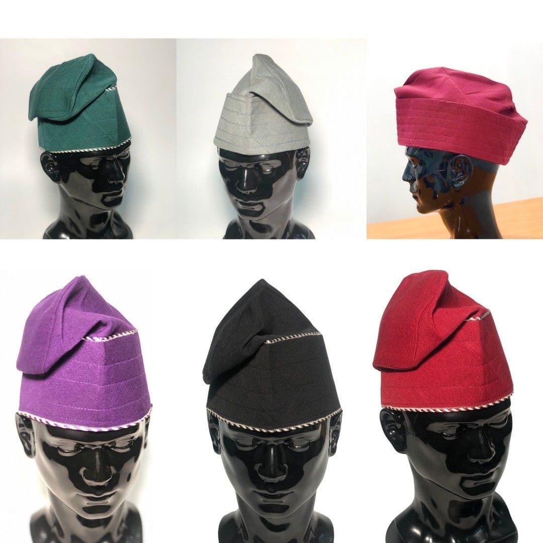 Six traditional Yoruba fila hats in various colors displayed on black mannequin heads.